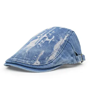 Side profile detail of vintage distressed blue denim newsboy cap with frayed design.