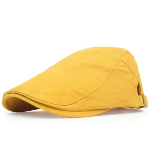 Detail view of a yellow cotton flat cap showing retro British style and texture.