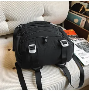 Detailansicht eines schwarzen Nylon-Wanderrucksacks mit Kordelzug und Reißverschluss