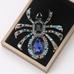 Gros plan détaillé d'une broche araignée étincelante en strass bleus dans son écrin cadeau