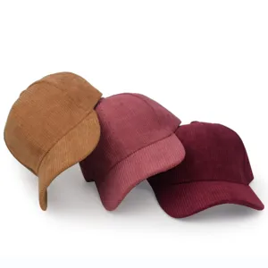 Detailed view of three corduroy baseball caps in tan, pink, and burgundy autumn shades