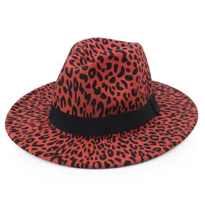 Vue détaillée d'un chapeau fedora rouge à motif léopard avec ruban noir et bord plat