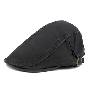 Side view of a classic black cotton flat cap with detailed stitching