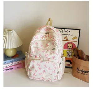Close-up of white backpack with pink bow pattern in a cozy lifestyle setting