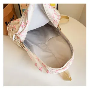 Detail view showing large interior capacity of cream backpack with pink bow pattern