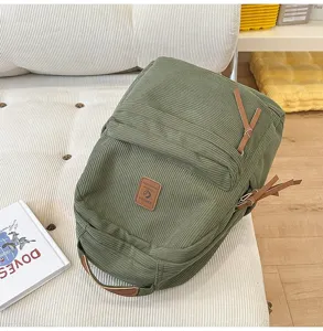 Dettaglio di uno zaino in velluto a coste verde dal design minimalista per scuola.