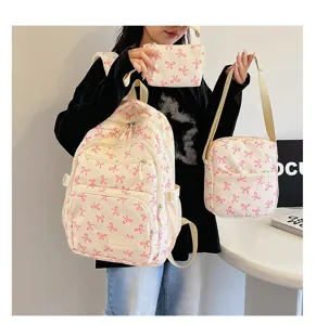 Three-piece schoolbag set with pink bow pattern held by model for college students