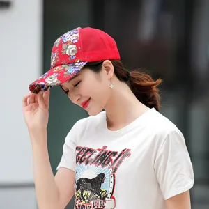 Woman wearing a stylish red floral mesh baseball cap for outdoor sun protection.