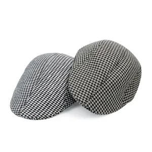 Macro view showing the classic houndstooth pattern and wool texture of newsboy caps.
