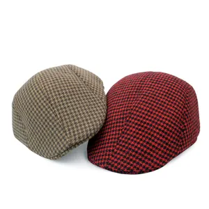 Detailed view of red and brown houndstooth wool flat caps on white background