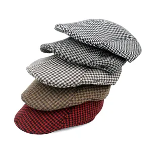 Detailed macro view showing a stack of classic houndstooth wool berets in various colors