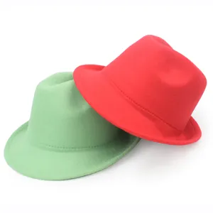 Close-up of overlapping green and red wool felt fedora hats with warm winter texture