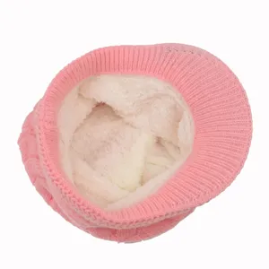 Detailansicht einer rosa Winterstrickmütze mit einem dicken, warmen weißen Fleecefutter innen