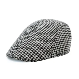 Detailed side view of a classic black and white houndstooth wool flat cap for men