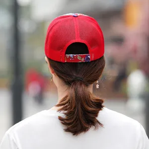 Back view of breathable red mesh baseball cap featuring elegant floral strap detail