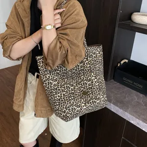 Leopard print canvas tote bag carried by a model in a casual lifestyle setting