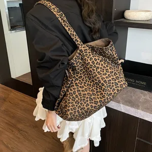 Leopard print canvas tote bag shown as a casual shoulder bag in a lifestyle setting