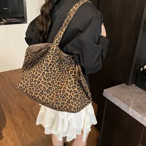 Large leopard print canvas tote bag carried by model in a casual street style outfit