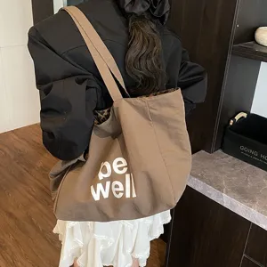 Macro view showing the 'be well' print and leopard lining on the canvas tote bag