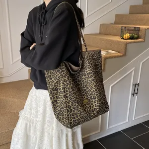 Detailed view of the large capacity leopard print canvas tote bag worn on shoulder by model