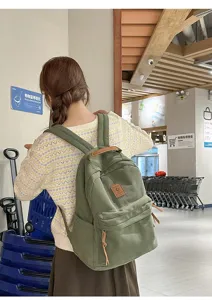 Zaino in velluto a coste verdi indossato da una studentessa in un centro commerciale.