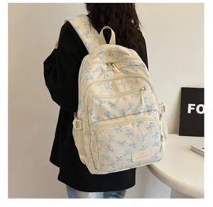 Detail view of a stylish cream backpack featuring blue ribbon patterns on a model's back
