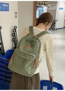 Vista posteriore di una donna con uno zaino in velluto verde in un centro commerciale.