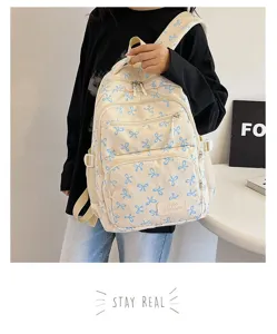 Close-up of a stylish white backpack with blue bow patterns for female students