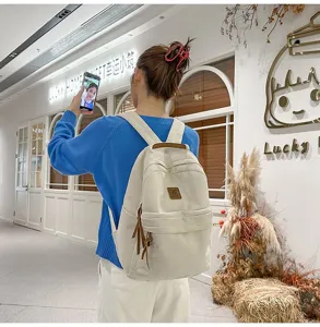 Zaino minimalista in velluto a coste stile coreano bianco sporco indossato da una studentessa