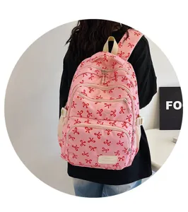 Detailed back view of a pink canvas backpack with cute red bow prints for college students