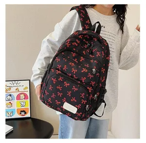 Asian student wearing a stylish black backpack with red bow prints in a casual indoor setting