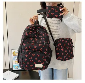Detailed view of the three-piece backpack set featuring vibrant red bow prints on black nylon