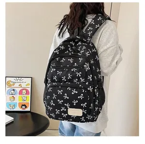 Stylish black backpack with white bow pattern worn by a model in a lifestyle setting