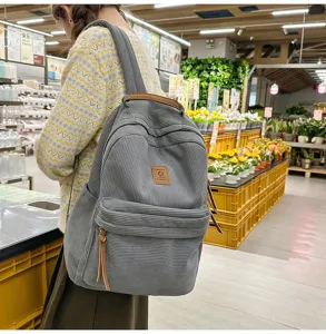 Dettagli dello zaino in velluto a coste grigio con texture di qualità e toppa in pelle