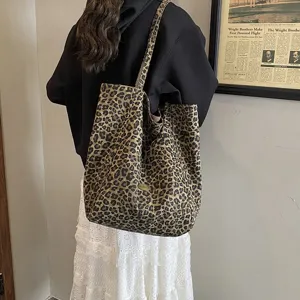 Large capacity leopard print canvas tote bag worn on shoulder by a model for daily use