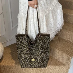 Detailed view of a stylish large leopard print canvas tote bag held by a fashion model