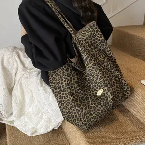 Detailed view of large leopard print canvas tote bag styled with casual outfit on stairs
