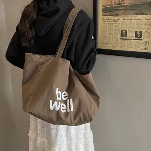 Large brown canvas tote bag with 'be well' slogan print and leopard print lining detail