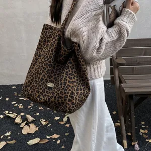 Side view of leopard print canvas tote bag worn by a model in an autumnal setting.