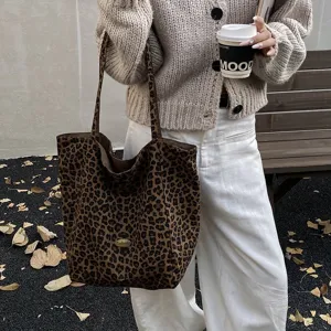 Lifestyle detail of a leopard print canvas tote bag carried by a model outdoors
