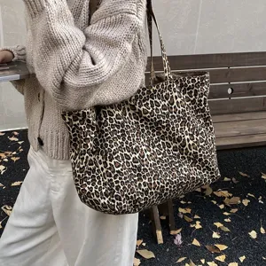 Lifestyle detail of a large leopard print canvas tote bag on a model's shoulder
