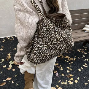 Casual leopard print canvas tote bag worn over the shoulder in an autumn setting