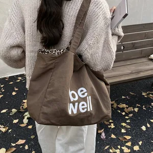 Large reversible brown canvas tote bag with leopard lining and white be well slogan print