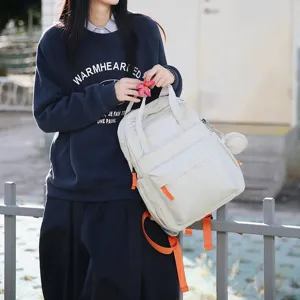 Étudiante tenant un sac à dos blanc de grande capacité avec accents orange