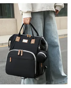 Detailansicht der schwarzen Wickeltasche mit braunen Ledergriffen im Freien gezeigt.