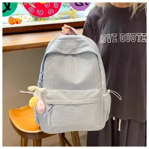 Vista dettagliata dello zaino scolastico a quadretti blu e bianchi con ciondolo in peluche