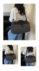 Vue détaillée d'un grand sac de voyage noir à carreaux porté par un mannequin en gris.