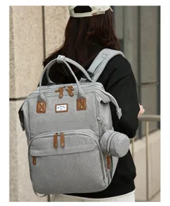 Rückansicht eines modischen grauen Windelrucksacks, getragen in städtischer Umgebung