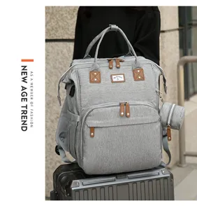 Grauer Wickelrucksack mit großem Fassungsvermögen und feinen Lederdetails auf Koffer