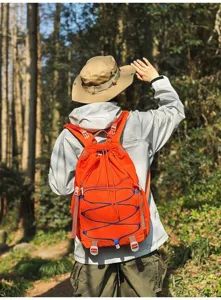 Leichter orangefarbener Wanderrucksack aus Nylon für Camping in einer Waldumgebung
